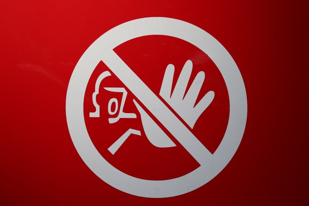 Simbolo rotondo di divieto con una mano a simboleggiare l'alt